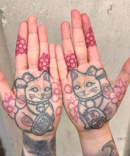 Hình xăm mèo thần tài trên lòng bàn tay thể hiện sự nắm bắt may mắn